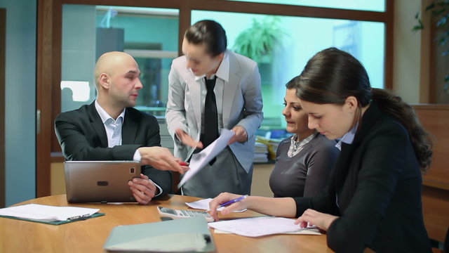 Female boss giving reprimand to her workers at business meeting