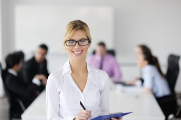 business woman standing with her staff in background