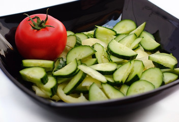 Black salad bowl with cucumber and tomato