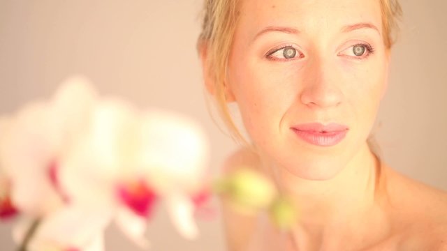 junge frau l&auml;chelt mit orchidee