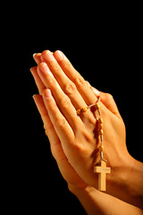 Christian human praying with rosary in hands