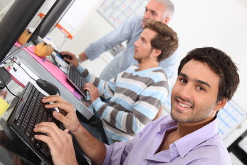Fototapeta na wymiar Smiling young man using a computer