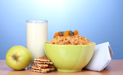 tasty cornflakes in green bowl, apples and glass of milk