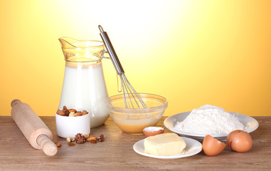Ingredients for the dough wooden table on yellow background