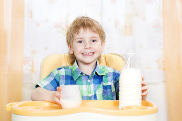 Obraz na płótnie Canvas mleko spożywcze dziecko. Trzymając szklankę mleka i siedzi na TA