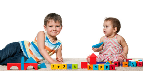 Smiling boy and a baby girl with blocks