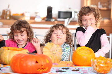 Fototapeta premium Giggling girls carving pumpkins