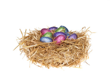 Fototapeta na wymiar Straw nest with chocolate Easter eggs