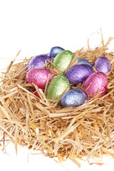 Fototapeta na wymiar Straw nest with chocolate Easter eggs