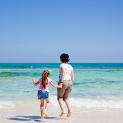 Naklejka premium mother and daughter play together by the end of the ocean