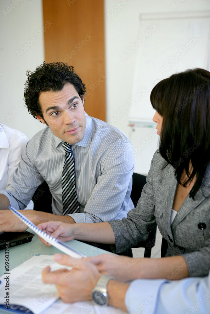 Wall mural worker explaining document to colleague