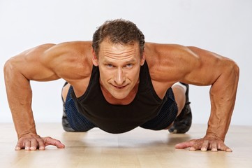 Obraz premium Handsome muscular man doing push-up.