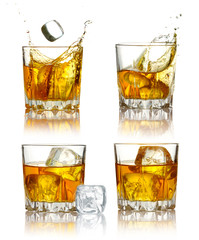 Set of scotch whiskey glasses with splash and ice isolated