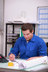 factory worker doing paper work in the office