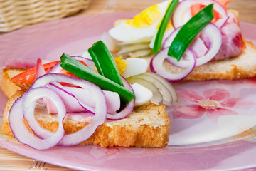 sandwich with smoked ham, cucumber, egg and onions