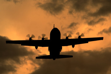 Lockheed C-130 Hercules turboprop cargo aircraft at sunset