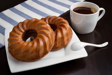 coffee cup, round cake on dark table