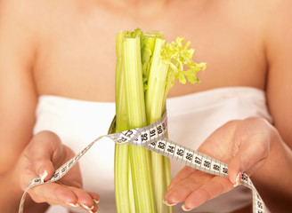 Young woman with vegetables and measuring tape
