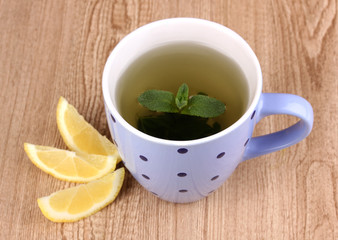 Mint tea with mint leaf and lemon on wooden background