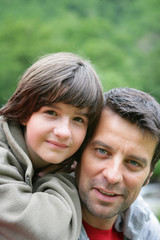 Child riding piggyback on his father's back