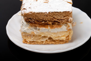 sweet  cake with cream isolated on black