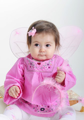 The small beautiful girl in pink clothes on a white background