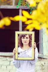 European young woman girl in white dress holding a frame window