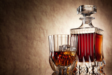 glass and decanter of brandy on a old stone background