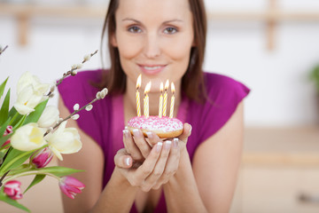 attraktive frau h&auml;lt geburtstagst&ouml;rtchen in ihren h&auml;nden
