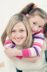 Carrying a generation: mom giving her daughter a piggyback ride