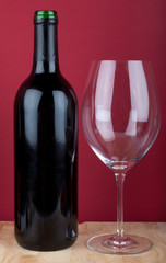 Wine bottle and wine glass on red background