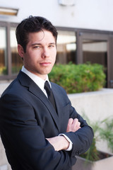 Portrait of a young businessman in suit standing outdoors