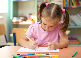Cute little girl is drawing with felt-tip pen