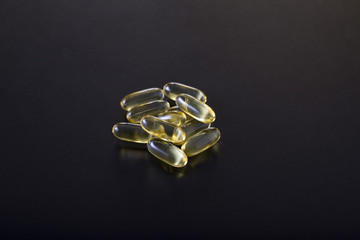Omega 3 fish oil capsules isolated on a black background