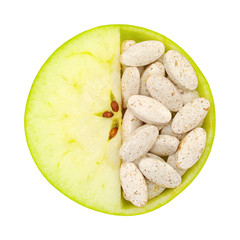 Close up of apple and pills isolated - vitamin concept