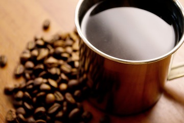 cup of coffee and coffee beans on a wooden table