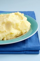 mashed potatoes in a bowl and a blue cloth on the table