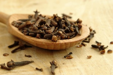 kitchen spice cloves in a wooden spoon on the board