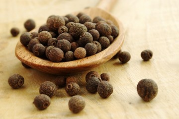 Fragrant pepper in a wooden spoon on a table