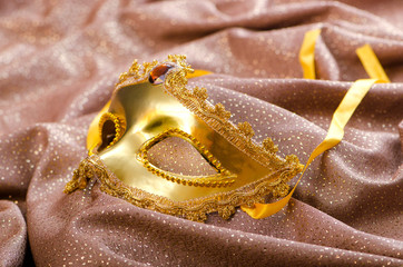 Golden mask on the satin background