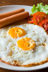 Fried eggs with sausages and Tomato