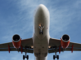 Close up of passenger plane landing overhead