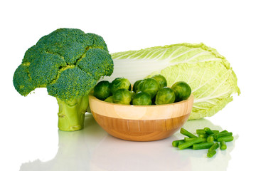 Brussels sprouts in wooden bowl with broccoli and cabbage