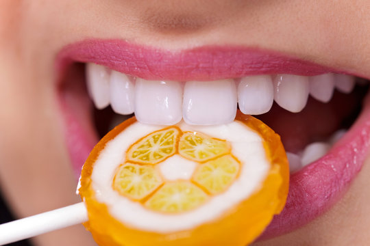 Healthy white teeth biting lollipop