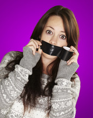 portrait of scared girl being silenced by herself over purple ba