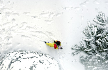 elevated view of girl playing on snow covered yard