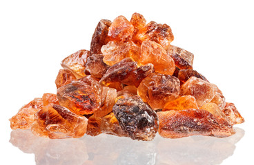 Brown lump cane sugar heap, isolated on white macro