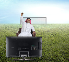 arabian man watching TV and reacting - front view
