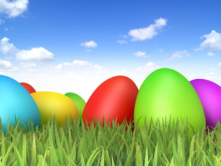 Easter Eggs sitting on grass field with blue sky background