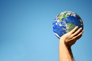 an image of hands holding globe and sky